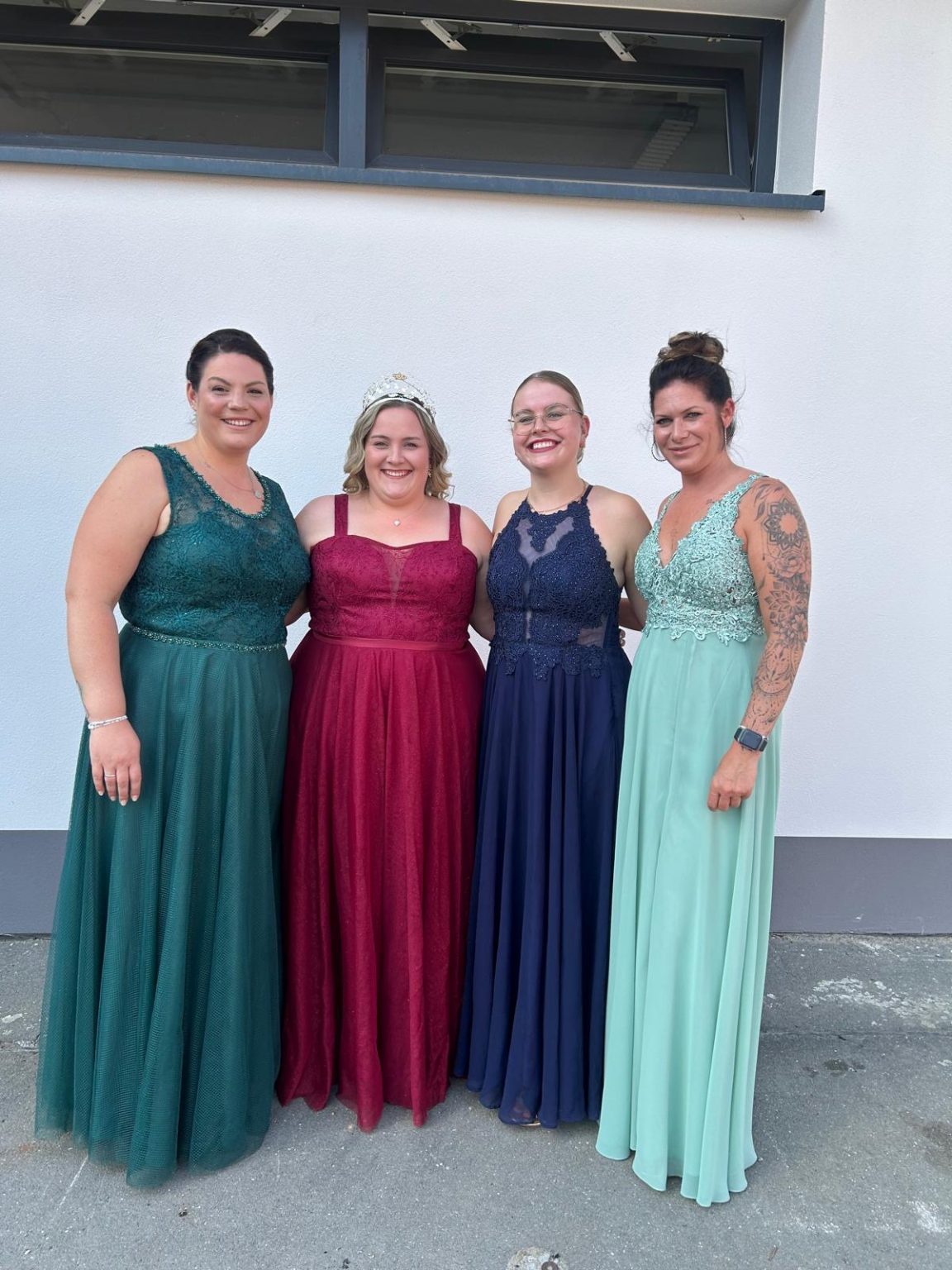 Königin Julia im roten Kleid mit drei Damen in Abendkleidern